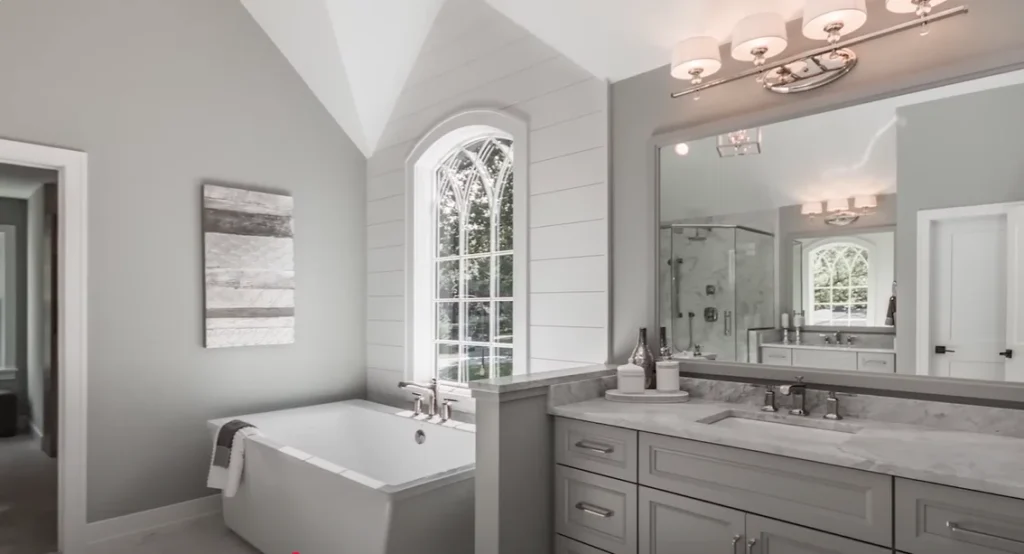Modern bathroom featuring a shower-to-tub conversion Shower to Tub Remodel Allentown PA with a freestanding bathtub, gray cabinetry, and arched window