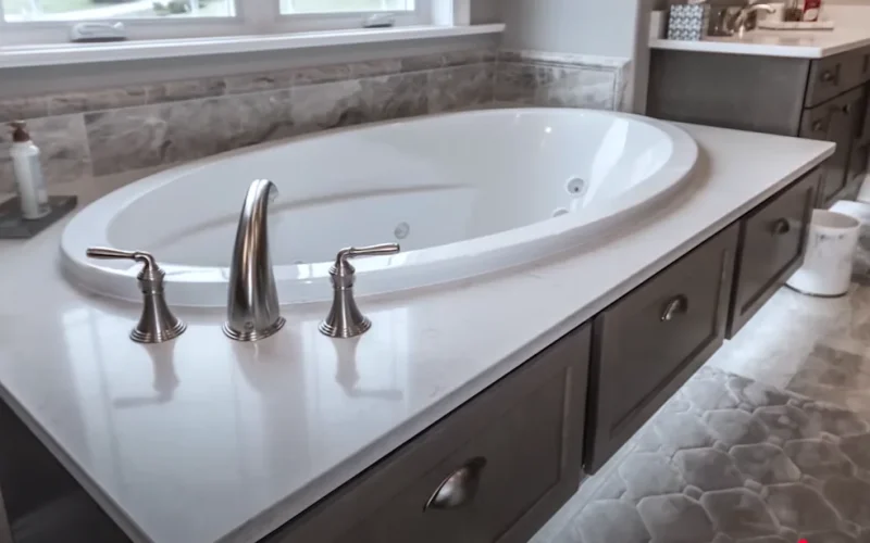 Modern bathroom with a white freestanding bathtub, chrome faucets, gray cabinetry, and tiled walls in Allentown, PA